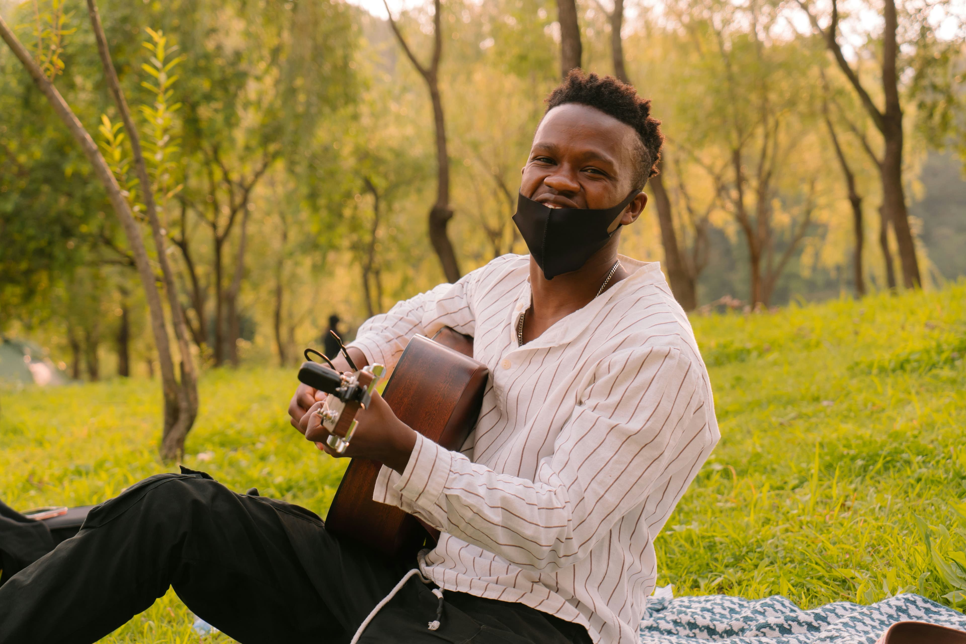 Mika Chavala playing guitar and singing in a park